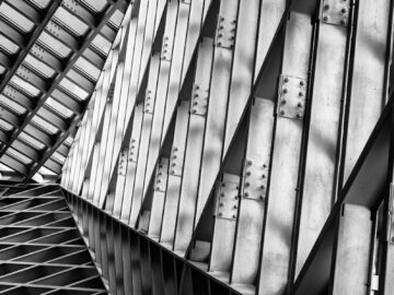 Black and white abstract view of industrial steel trusses in modern architecture.