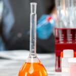 A close-up shot of a laboratory flask with orange liquid, highlighting scientific research equipment.