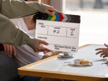Film crew sets up with a clapperboard on a movie set, capturing a candid moment.