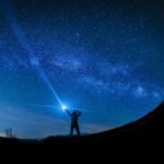 silhouette of man holding flashlight