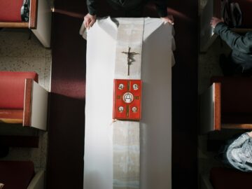 A priest prepares a church altar for service.