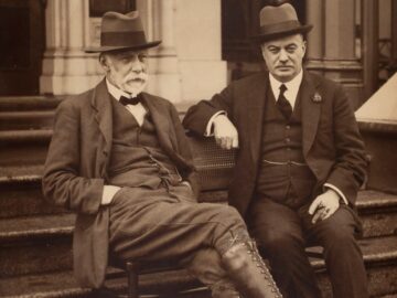 man in black suit sitting on stairs