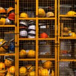 a rack filled with lots of yellow hard hats