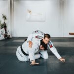 man in white and black jacket and pants sitting on black floor
