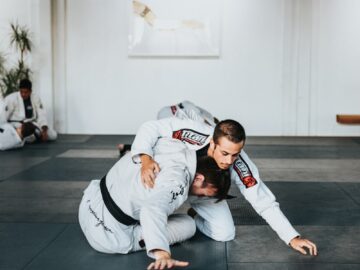 man in white and black jacket and pants sitting on black floor